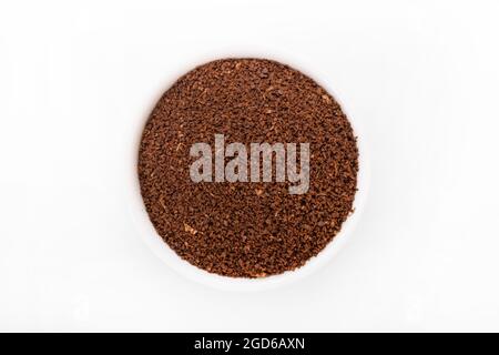Gemahlener Kaffee. Gemahlener Kaffee in einer weißen Schüssel auf weißem Hintergrund. Makroaufnahme gemahlener Kaffee Stockfoto