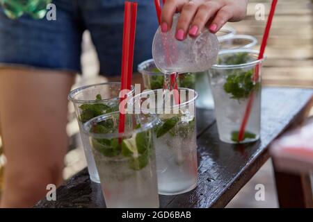 Junge Frau auf einer Junggesellinnenparty macht einen Mojito-Cocktail für die Firma. Anweisungen zur Vorbereitung. Schritt 2. Hochwertige Fotos Stockfoto