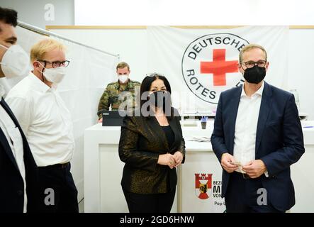 11. August 2021, Berlin: Oliver Hanna (l-r), Zentrumsleiter des Alexa-Einkaufszentrums, Ephraim Gothe (SPD), Bezirksrat für Stadtentwicklung, Dilek Kalayci (SPD), Senator für Gesundheit und Michael Müller (SPD), Regierender Bürgermeister von Berlin, stehen im neu eröffneten Impfzentrum im Berliner Alexa-Einkaufszentrum. Michael Müller (SPD), Regierender Bürgermeister von Berlin, steht im Hintergrund. Von Montag bis Samstag zwischen 10-17 Uhr haben Besucher die Möglichkeit, sich direkt vor Ort impfen zu lassen. Im Pop-up-Impfzentrum im Einkaufszentrum Impfstoffe von Johnson&Johnson an Stockfoto