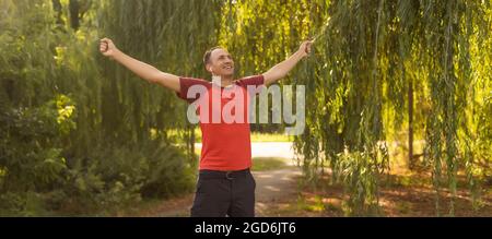 Erfolgreicher Mann, der im Sommer nach dem Cross-Track-Rennen die Arme hebt Stockfoto