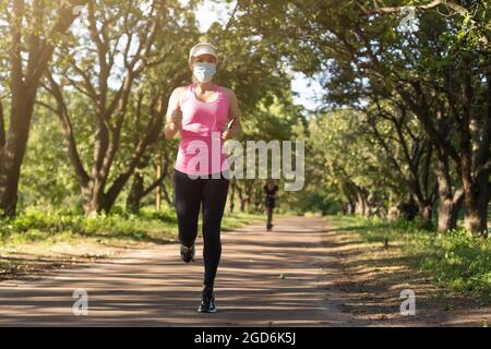 COVID-19. Frau s geht während einer Pandemie auf einem Straßensportplatz Sport. Coronavirus in Europa. Stockfoto