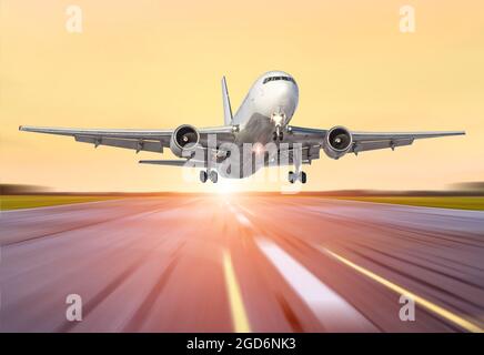 Großes Flugzeug in Bewegung Start der Abendhimmel Sonnenuntergang Sonnenaufgang Sonne Flughafen. Stockfoto