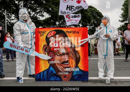 Demonstranten, die Schutzkleidung mit Spruchbändern tragen, halten sich vor der letzten Rede von Präsident Rodrigo Duterte zum Nationalstaat in Quezon City, Metro Manila, auf. Tausende von linken Demonstranten versammelten sich und marschierten auf den philippinischen Kongress zu, wo Duterte seine Rede zum endgültigen Zustand der Nation hielt und seine sechsjährige Amtszeit angesichts von Kritiken wie angeblichen Menschenrechtsverletzungen abschreckte. Falsche Handhabung der Coronavirus-Pandemie und Untätigkeit, um Chinas aggressives Verhalten im umstrittenen Südchinesischen Meer zu bekämpfen. Philippinen. Stockfoto