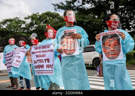 Demonstranten, die Schutzkleidung mit Spruchbändern tragen, halten sich vor der letzten Rede von Präsident Rodrigo Duterte zum Nationalstaat in Quezon City, Metro Manila, auf. Tausende von linken Demonstranten versammelten sich und marschierten auf den philippinischen Kongress zu, wo Duterte seine Rede zum endgültigen Zustand der Nation hielt und seine sechsjährige Amtszeit angesichts von Kritiken wie angeblichen Menschenrechtsverletzungen abschreckte. Falsche Handhabung der Coronavirus-Pandemie und Untätigkeit, um Chinas aggressives Verhalten im umstrittenen Südchinesischen Meer zu bekämpfen. Philippinen. Stockfoto