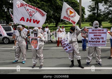 Demonstranten, die Schutzkleidung mit Spruchbändern tragen, halten sich vor der letzten Rede von Präsident Rodrigo Duterte zum Nationalstaat in Quezon City, Metro Manila, auf. Tausende von linken Demonstranten versammelten sich und marschierten auf den philippinischen Kongress zu, wo Duterte seine Rede zum endgültigen Zustand der Nation hielt und seine sechsjährige Amtszeit angesichts von Kritiken wie angeblichen Menschenrechtsverletzungen abschreckte. Falsche Handhabung der Coronavirus-Pandemie und Untätigkeit, um Chinas aggressives Verhalten im umstrittenen Südchinesischen Meer zu bekämpfen. Philippinen. Stockfoto