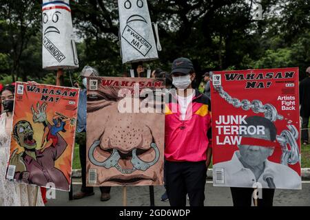 Demonstranten, die Schutzkleidung mit Spruchbändern tragen, halten sich vor der letzten Rede von Präsident Rodrigo Duterte zum Nationalstaat in Quezon City, Metro Manila, auf. Tausende von linken Demonstranten versammelten sich und marschierten auf den philippinischen Kongress zu, wo Duterte seine Rede zum endgültigen Zustand der Nation hielt und seine sechsjährige Amtszeit angesichts von Kritiken wie angeblichen Menschenrechtsverletzungen abschreckte. Falsche Handhabung der Coronavirus-Pandemie und Untätigkeit, um Chinas aggressives Verhalten im umstrittenen Südchinesischen Meer zu bekämpfen. Philippinen. Stockfoto