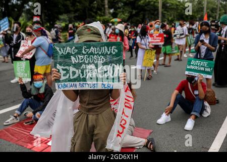 Demonstranten, die Schutzkleidung mit Spruchbändern tragen, halten sich vor der letzten Rede von Präsident Rodrigo Duterte zum Nationalstaat in Quezon City, Metro Manila, auf. Tausende von linken Demonstranten versammelten sich und marschierten auf den philippinischen Kongress zu, wo Duterte seine Rede zum endgültigen Zustand der Nation hielt und seine sechsjährige Amtszeit angesichts von Kritiken wie angeblichen Menschenrechtsverletzungen abschreckte. Falsche Handhabung der Coronavirus-Pandemie und Untätigkeit, um Chinas aggressives Verhalten im umstrittenen Südchinesischen Meer zu bekämpfen. Philippinen. Stockfoto