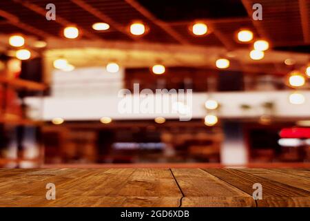 Leere Holztischplatte mit Blur Coffee Shop oder Restaurant Interieur Hintergrund Stockfoto