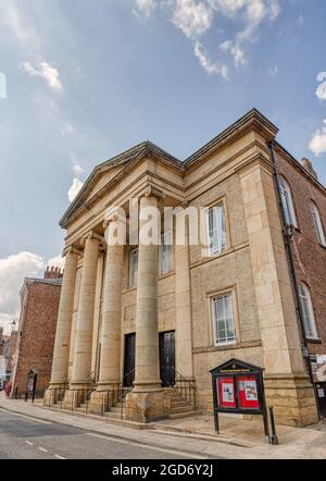 Hohe Säulen am Eingang einer methodistischen Kirche. Stufen führen zu den Türen und im Vordergrund steht ein Hinweisbrett. Stockfoto