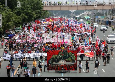 Demonstranten, die Schutzkleidung tragen, marschieren vor der letzten Rede von Präsident Rodrigo Duterte in Quezon City, Metro Manila. Tausende von linken Demonstranten versammelten sich und marschierten auf den philippinischen Kongress zu, wo Duterte seine Rede zum endgültigen Zustand der Nation hielt und seine sechsjährige Amtszeit angesichts von Kritiken wie angeblichen Menschenrechtsverletzungen abschreckte. Falsche Handhabung der Coronavirus-Pandemie und Untätigkeit, um Chinas aggressives Verhalten im umstrittenen Südchinesischen Meer zu bekämpfen. Philippinen. Stockfoto