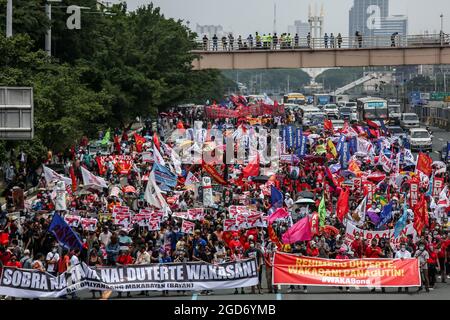 Demonstranten, die Schutzkleidung tragen, marschieren vor der letzten Rede von Präsident Rodrigo Duterte in Quezon City, Metro Manila. Tausende von linken Demonstranten versammelten sich und marschierten auf den philippinischen Kongress zu, wo Duterte seine Rede zum endgültigen Zustand der Nation hielt und seine sechsjährige Amtszeit angesichts von Kritiken wie angeblichen Menschenrechtsverletzungen abschreckte. Falsche Handhabung der Coronavirus-Pandemie und Untätigkeit, um Chinas aggressives Verhalten im umstrittenen Südchinesischen Meer zu bekämpfen. Philippinen. Stockfoto