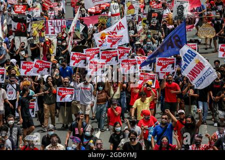 Demonstranten, die Schutzkleidung tragen, marschieren vor der letzten Rede von Präsident Rodrigo Duterte in Quezon City, Metro Manila. Tausende von linken Demonstranten versammelten sich und marschierten auf den philippinischen Kongress zu, wo Duterte seine Rede zum endgültigen Zustand der Nation hielt und seine sechsjährige Amtszeit angesichts von Kritiken wie angeblichen Menschenrechtsverletzungen abschreckte. Falsche Handhabung der Coronavirus-Pandemie und Untätigkeit, um Chinas aggressives Verhalten im umstrittenen Südchinesischen Meer zu bekämpfen. Philippinen. Stockfoto