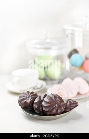 Schokoladenüberzogene Marschmalchen, traditionelles russisches zephyr in Schokolade auf einem hellen Tisch. Selektiver Fokus Stockfoto