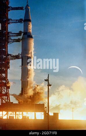Eine Saturn-V-Rakete hebt sich von Cape Canaveral in Florida mit dem Halbmond dahinter ab. Dies ist Apollo 8, der Frank Borman, James Lovell und William anders in die Umlaufbahn um den Mond brachte. Es startete am 21. Dezember 1968 und war das erste Mal, dass der Mensch die Erdorbit verließ. Stockfoto