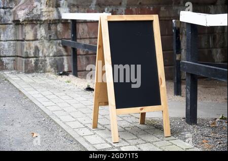 Tafel mit leerem Holzschild vor dem Café Stockfoto