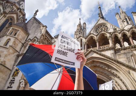 London, Großbritannien. August 2021. Ein Demonstrator hält ein Plakat mit der Aufschrift „Australien: Bringt Assange nach Hause“ während des Protestes vor den Royal Courts of Justice, wo die Vorverhandlung für die US-Berufung gegen die Entscheidung, WikiLeaks-Gründer Julian Assange nicht auszuliefern, stattfand. (Foto: Vuk Valcic/SOPA Images/Sipa USA) Quelle: SIPA USA/Alamy Live News Stockfoto