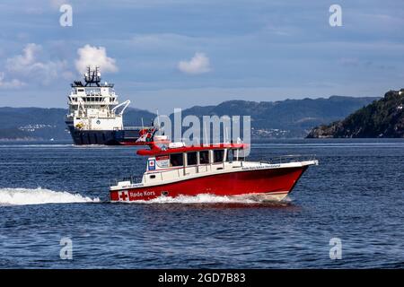 Red Cross SAR-Schiff Hordaland Røde Kors båten in Byfjorden, Bergen, Norwegen Offshore-Versorgungsschiff Island Chieftain im Hintergrund Stockfoto