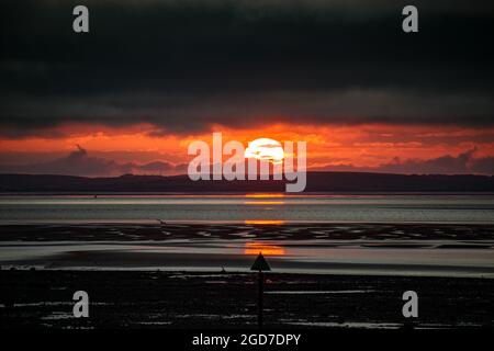 Heysham, Lancashire, Großbritannien. August 2021. Sonne bricht durch die Wolken, bevor sie über Morecambe Bay untergeht Kredit: PN News/Alamy Live News Stockfoto