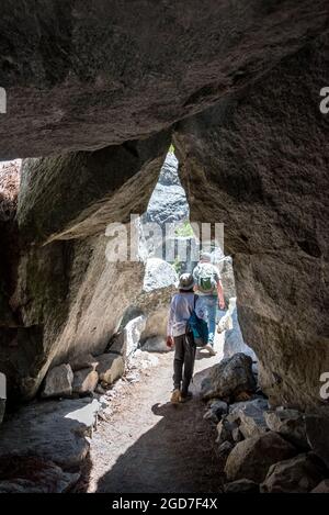 Der River Trail führt Wanderer durch einen kurzen Tunnel aus großen Granitblöcken auf ihrem Weg zum Ende der Road im Kings Canyon National Park. Stockfoto