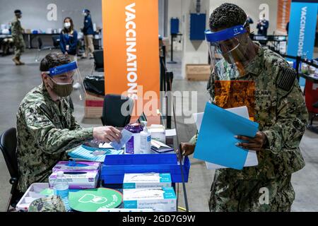 Matthew Tuten, Hospitalist der US-Marine (links), gebürtiger Wichita Falls, Texas, Und Kenecha Campbell (rechts), ein aus Orlando, Florida, geborener Hospitalist der US-Marine, der dem Naval Medical Center Portsmouth, Virginia, zugewiesen wurde, füllt COVID-19-Impfstoffe an ihren zugewiesenen Stationen im Hynes Convention Center COVID-19 Community Vaccine Center in Boston, 2. April 2021. Seeleute der US-Marine aus dem ganzen Land werden zur Unterstützung der Bemühungen des Verteidigungsministeriums um Impfungen eingesetzt. Das U.S. Northern Command setzt sich über die U.S. Army North weiterhin für eine fortgesetzte, flexible Unterstützung des Verteidigungsministeriums ein Stockfoto