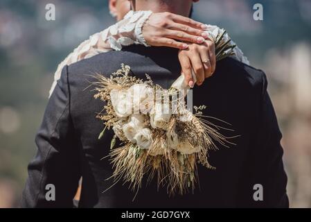 Brauthänden mit Trauring und Blumenstrauß aus nächster Nähe Stockfoto