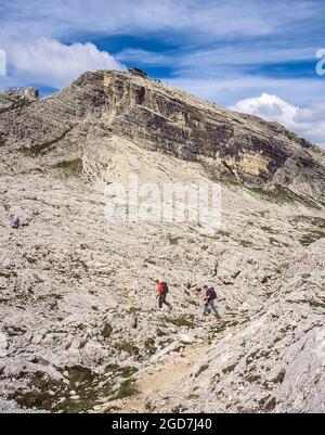 Eine Gruppe von Menschen macht sich auf den Weg über die Felsen zur Hütte Rifugio Nuvolau unweit der Ortschaft Cortina d'Ampezzo in den italienischen Dolomiten Stockfoto