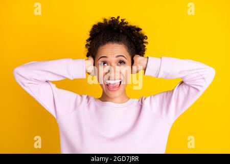 Porträt von verärgerten gereizte dunkle Haut Person Arme decken Ohren Blick leeren Raum auf gelben Hintergrund isoliert Stockfoto