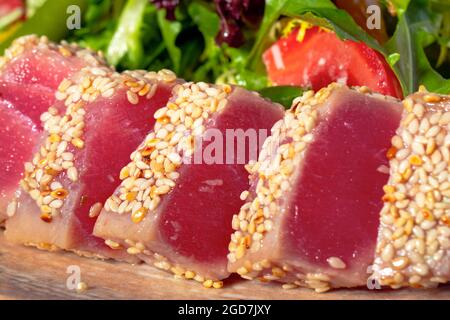 Rucola und pochiertes Ei mit gegrilltem Thunfisch und mit Sesam bestreut Stockfoto