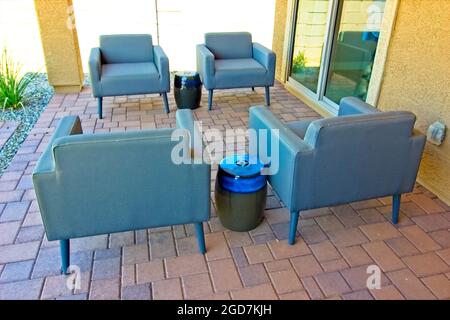 Vier Blaue Armstühle Im Deckungsbereich Der Paver Patio Stockfoto