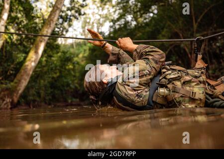 1. LT. Brianne Hanley vom Kampfteam der 3. Infanterie-Brigade, 25. Infanterie-Division überquert am 6. Tag des Jungle Operations Training Course (JOTC) in East Range, Hawaii, am 27. März 2021 einen Fluss mit einer Seilbrücke. Führende Anführer und Soldaten der 25. Infanterie-Division nehmen an JOTC Teil, um sich mit den Taktiken, Techniken und Verfahren der Dschungeloperation vertraut zu machen, die für den Kampf, Sieg und das Überleben in jeder tropischen Dschungelumgebung erforderlich sind. (USA Foto der Armee von 1. LT. Angelo Mejia) Stockfoto