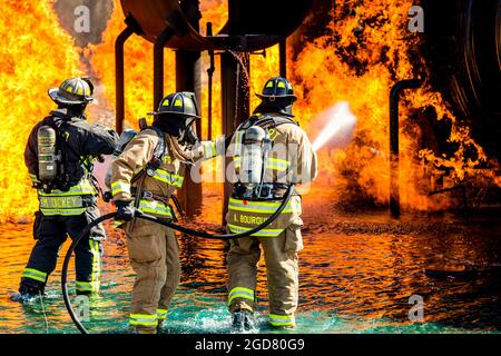 Feuerwehrleute der 788. Zivilingenieur-Squadron-Feuerwehr und der Feuerwehr des Flughafens Dayton sprühen Wasser auf einen brennenden Flugzeugschulrumpf auf der Wright-Patterson Air Force Base, Ohio, 26. April 2021. Die Mitarbeiter der 788. CES-Feuerwehr trainieren ständig, um sicherzustellen, dass ihre Fähigkeiten immer auf dem neuesten Stand sind. (USA Luftwaffe Foto von Wesley Farnsworth) Stockfoto