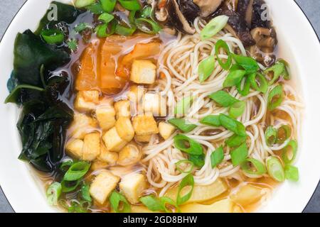Vegane Ramen-Suppe mit Nudel, Pilzen, Tofu und Gemüse Stockfoto
