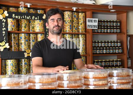 Marmaris, Türkei. August 2021. Volkan Yildiz steht in seinem Laden. Die Imker müssen hart mit den Folgen der Waldbrände kämpfen, denn viele der verbrannten Bäume sind für die Produktion von Kiefernhonig unverzichtbar. Quelle: Anne Pollmann/dpa/Alamy Live News Stockfoto