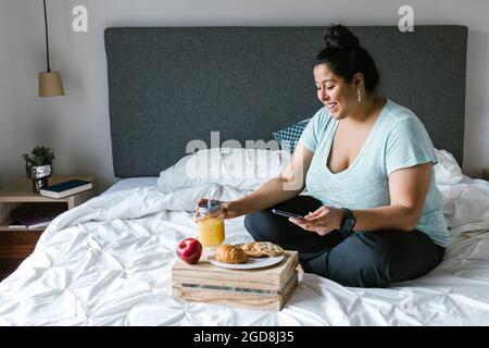 Junge lateinamerikanische plus-große Frau beim Frühstück in ihrem Zimmer in Lateinamerika Stockfoto