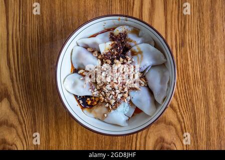 ZhongShuiJiaozi dampfte chinesische Knödel mit Erdnusssoße auf einer Tischansicht Stockfoto