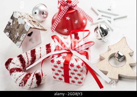 Weihnachtsgeschenk, Glocke und Weihnachtsstab. Moderne Lifestyle-Komposition im skandinavischen Stil Stockfoto