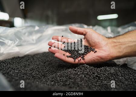 Nahaufnahme der männlichen Hand mit Kunststoffpolymergranulat Stockfoto