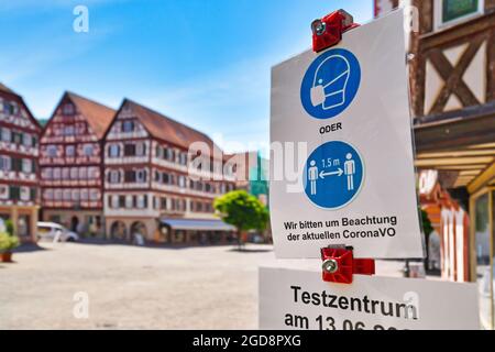 Mosbach, Deutschland - Juni 2021: Schilder für Gesichtsmaske und Entfernungsanforderungen in deutscher Stadt mit dem Text 'Bitte beachten Sie die aktuelle Corona-Registrierung Stockfoto