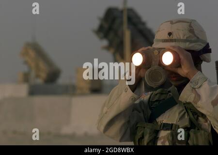 Bobby Jenkins, SPEZIALIST DER US-Armee (USA) der vierten Klasse (SPC4), der dem Delta/Battery, 3. Bataillon-43. Air Defense Artillery (ADA) Regiment, zugewiesen wurde, scannt mit einem Fernglas die Landschaft um seine Patriot-Raketen in Al Udeid ab, Katar. (USAF-FOTO VON MSGT TERRY L. BLEVINS 030215-F-5712B-003) Stockfoto