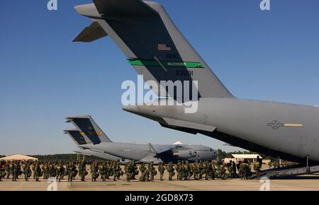 Mitglieder DER US Army (USA) der 82nd Airborne Division (AD), Fort Bragg, North Carolina (NC), bereiten sich auf den Einsatz eines Frachtflugzeugs der US Air Force (USAF) C-17A Loadmaster III vom 62. Luftliftflügel, der McChord Air Force Base (AFB), Washington (WA), Und die 437th AW, Charleston AFB, South Carolina (SC), für einen Multi-Aircraft-Sprung im Rahmen des Exercise Large Package auf der Pope AFB, North Carolina (NC). Die „Large Package Week“ ist eine gemeinsame Übung zwischen dem USAF und den USA, die die Zusammenarbeit zwischen den Dienststellen verbessern soll. (USAF-FOTO VON TSGT MIKE BUYTAS 031202-F-9085B-008) Stockfoto