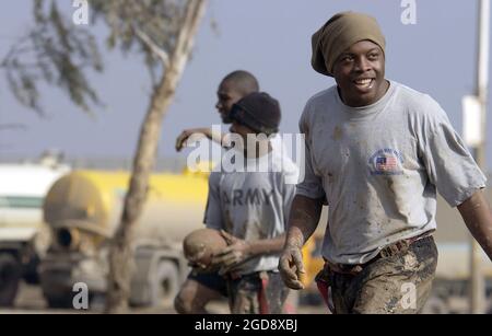 Soldaten DER US-Armee (USA) der 1. Panzerdivision (AD), Fort Bliss, Texas (TX), und der 447th Air Expeditionary Group (AEG) auf dem Feld für ein Army-Verse-Luftwaffenspiel im Wolverine Field, Baghdad International Airport (BIAP), Irak, während der Operation IRAQI FREEDOM. (USAF-FOTO VON SSGT STACY L. PEARSALL 031230-F-7234P-039) Stockfoto