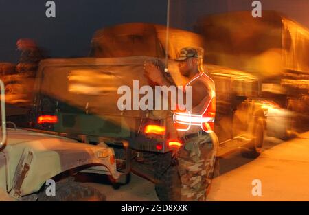 US Army (USA) Specialist Fourth Class (SPC) Joseph Thorne, 3. Bataillon (BN), 112. Field Artillery (FA), New Jersey Army National Guard (NJARNG), Morristown, New Jersey (NJ), führt Fahrzeuge in Position, wenn sie an der Zwischenstation in der Nähe von Alexandria, Louisiana (LA) ankommen. Mehr als 2,000 Fahrzeuge und 4,000 Truppen wurden am zentralen Standort Louisianas versammelt, um nach dem Orkans Rita Aufträge für Bergemissionen an der Golfküste Louisianas zu erhalten. (USAF-FOTO VON TSGT ROGER M. DEY 050925-F-4970D-103) Stockfoto