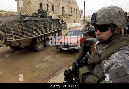 US Army (USA) Specialist Fourth Class (SPC) Jimmy Wilkes (vorne rechts), 2. Bataillon (BN), 1. Infanterie-Regiment (2/1.), 172. Stryker Brigade Combat Team (SBCT), bietet Sicherheit für eine Absperrungs- und Suchoperation in Tall Kayf, Provinz Ninawa, Irak (IRQ), die während der Operation IRAQI FREEDOM durchgeführt wird. (USAF-FOTO VON TSGT JOHN M. FOSTER 060301-F-2869F-211) Stockfoto