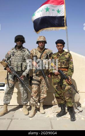 US Army (USA) Oberstleutnant (LTC) Bruce Patrick (links), Multi-National Division Central-South (MND-CS), macht eine Pause, um mit dem dänischen Armeehauptmann (CPT) Benny Gottlieb (Mitte) und einem irakischen Grenzpolizisten (IBP) (rechts) im IBP Fort Karmashiya, Irak (IRQ) zu posieren, Während der Teilnahme an einer offiziellen Koalitionstruppe-Tour von fünf IBP-Festungen an der iranisch-irakischen Grenze, die während der Operation IRAQI FREEDOM durchgeführt wurde. (USAF-FOTO VON SRA JASON T BAILEY 060325-F-0560B-301) Stockfoto