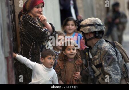 US Army (USA) Leutnant (LT) Kylen Mays (rechts), 1. Brigade, 1. Panzerdivision (AD), spricht mit einer lokalen irakischen Familie, während sie an einer Luftangriffspatrouille in Tall Afar, Provinz Ninawa (Al-Jazeera Desert Area), Irak (IRQ), während der Operation IRAQI FREEDOM teilnimmt. (USAF-FOTO VON SSGT AARON D. ALLMON II 060408-F-7823A-087) Stockfoto