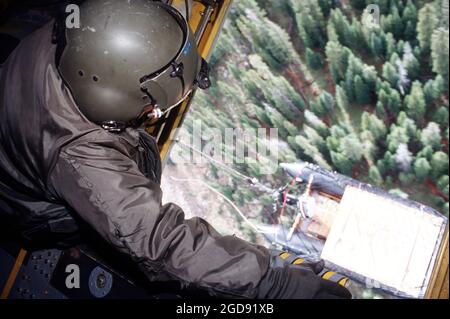 Ein Flugingenieur auf dem Hubschrauber CH-47 aus Abteilung 1, Firma G, 140th Aviation, Die Nationalgarde der Nevada Army hat ein Auge auf das Mark V Zodiac-Boot, das zum Durchsuchen der Seen und Teiche nach den 500-Pfund-Mark-82-Bomben verwendet wurde, die von der A-10 getragen wurden, die auf dem nahe gelegenen Gold Dust Peak abgestürzt ist. (USAF-FOTO VON SSGT DAVID W. RICHARDS 970911-F-2829R-007) Stockfoto