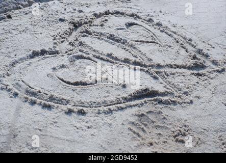 Auf dem Sand ist ein Bild von zwei Herzen. Stockfoto