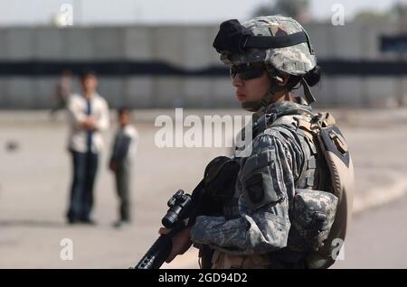 US Army (USA) Private First Class (PFC) Brandie Leon, Bravo Company (B Co), 4th Brigade Combat Team (BCT), 506th Regimental Combat Team (RCT), 101st Airborne Division (Air Assault), bietet Sicherheit für andere US-Soldaten, die mit Elementen der irakischen Armee (IA) in Bagdad, Provinz Bagdad, patrouillieren, Irak (IRQ), um den Frieden in der Region zu erhalten, nachdem während der Operation IRAQI FREEDOM vor kurzem eine Reihe von Bombenanschlägen gegen Moscheen von religiösen Extremisten durchgeführt wurde. (US NAVY FOTO VON PH1 (AW) BART A BAUER 060303-N-7586B-079) Stockfoto