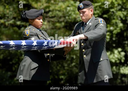 Soldaten DER US-Armee (USA) aus Fort Eustis, Virginia (VA), falten die Flagge bei der Enthüllung und Einweihung der Gedenkmarke für den US-Sergeant Major (SGM) Edward Ratcliff, Träger der Civil war Medal of Honor, auf dem Cheesecake Cemetery der US Navy (USN) Naval Weapons Station (NWS) in Yorktown. USA SGM Ratcliff diente in der 38. Regimental United States Colored Infantry Company C. USA SGM Ratcliff (als First Sergeant (1SG)) "kommandierte und führte seine Firma gnadenlos an, nachdem der Kommandooffizier getötet wurde" bei der Schlacht von Chaffin's Farm am 1864. September. Stockfoto