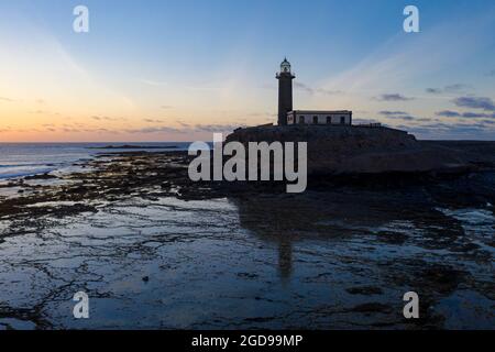 Der Leuchtturm Punta Jandia (Faro de la Lola) spiegelt sich im Meer bei Sonnenuntergang wider, Fuerteventura, Kanarische Inseln, Spanien Stockfoto